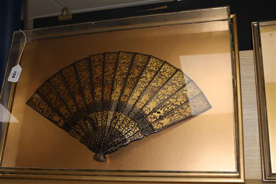 A large Chinese export gilt decorated black lacquer fan, mid 19th century, length 31cm, perspex case